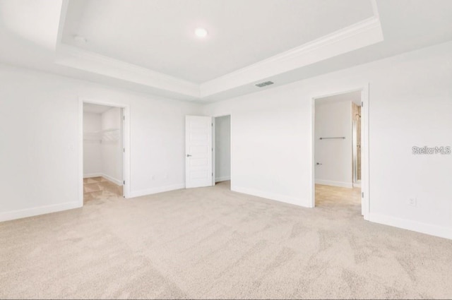 7002 162nd Pl E, Parrish, FL 34219 - unfurnished bedroom with visible vents, light carpet, a tray ceiling, and a spacious closet
