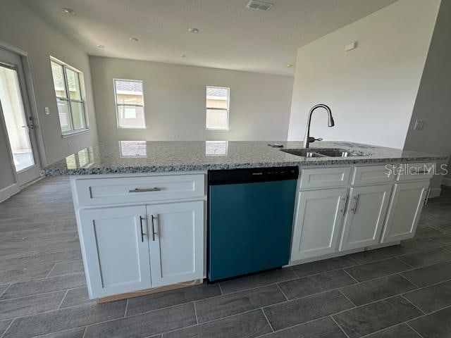 7002 162nd Pl E, Parrish, FL 34219 - kitchen featuring dishwasher, white cabinets, light stone countertops, and a sink