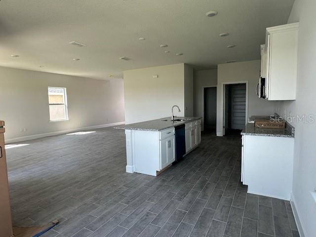 7002 162nd Pl E, Parrish, FL 34219 - kitchen with baseboards, white cabinetry, black dishwasher, and dark wood-style flooring