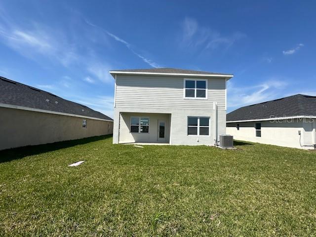 7002 162nd Pl E, Parrish, FL 34219 - back of property featuring a lawn and central AC