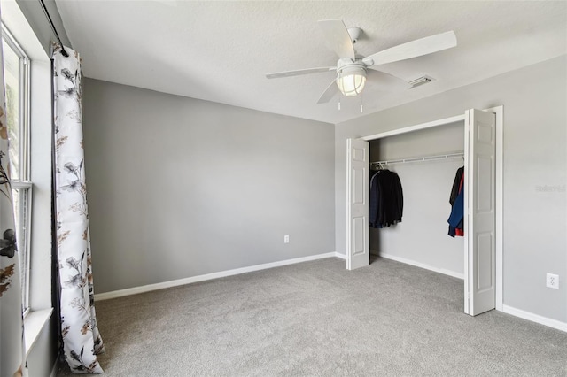 unfurnished bedroom featuring light colored carpet, a closet, and ceiling fan