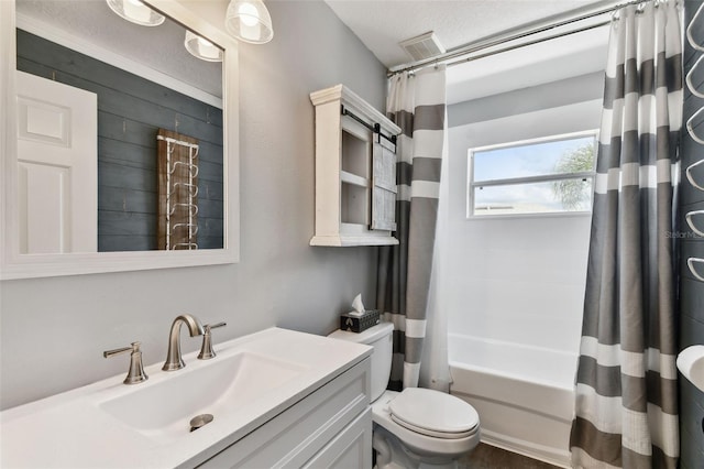 full bathroom with toilet, oversized vanity, shower / bath combo with shower curtain, and a textured ceiling