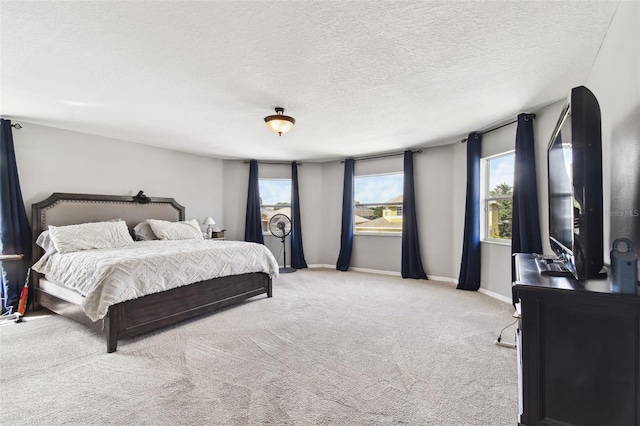 bedroom featuring light colored carpet and a textured ceiling