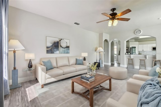 living room with light hardwood / wood-style flooring and ceiling fan