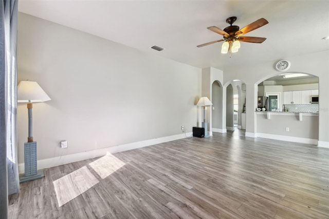 unfurnished living room featuring ceiling fan and light hardwood / wood-style floors