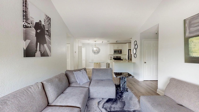 living room featuring an inviting chandelier and light hardwood / wood-style flooring