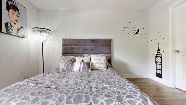 bedroom with dark wood-type flooring and a textured ceiling