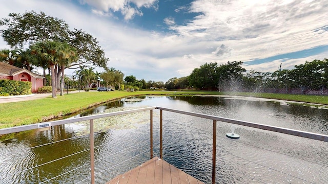 dock area with a water view and a yard