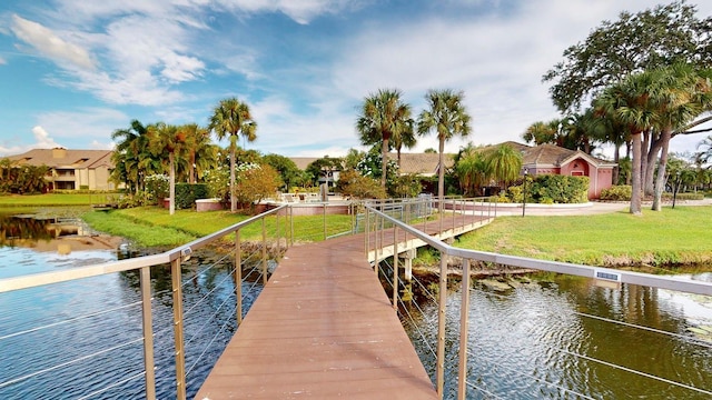 view of dock with a water view and a lawn