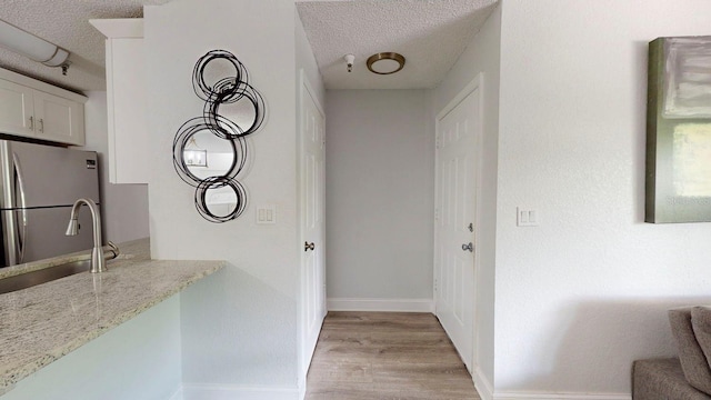 interior space with light hardwood / wood-style floors, a textured ceiling, and sink