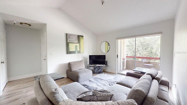 living room featuring lofted ceiling, a textured ceiling, and light hardwood / wood-style flooring