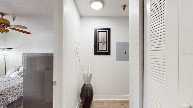 corridor with a textured ceiling and wood-type flooring