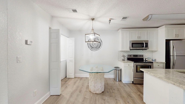 kitchen with backsplash, stainless steel appliances, light hardwood / wood-style flooring, and white cabinetry