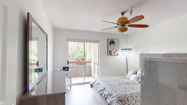 bedroom with a textured ceiling, ceiling fan, and access to outside