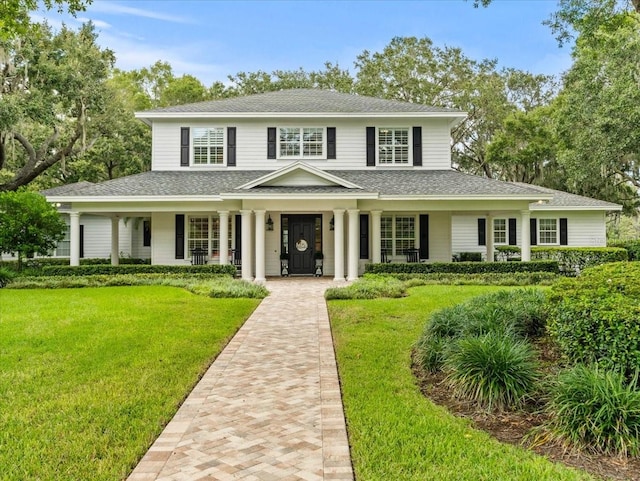 farmhouse inspired home with covered porch and a front lawn