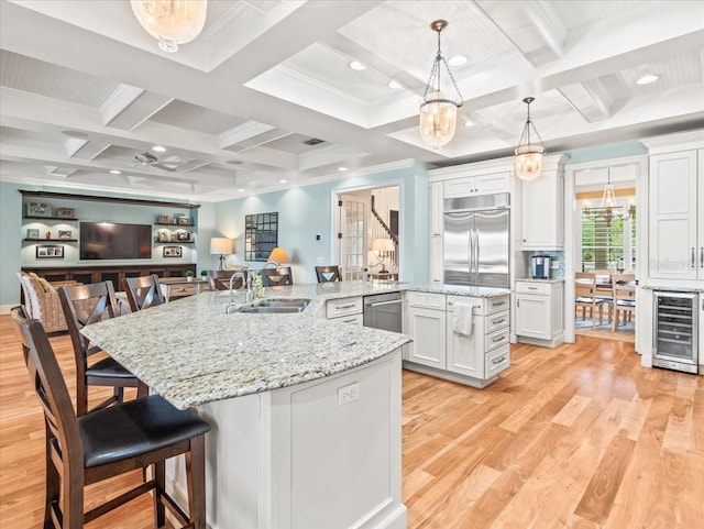 kitchen with sink, a breakfast bar area, stainless steel appliances, coffered ceiling, and white cabinetry