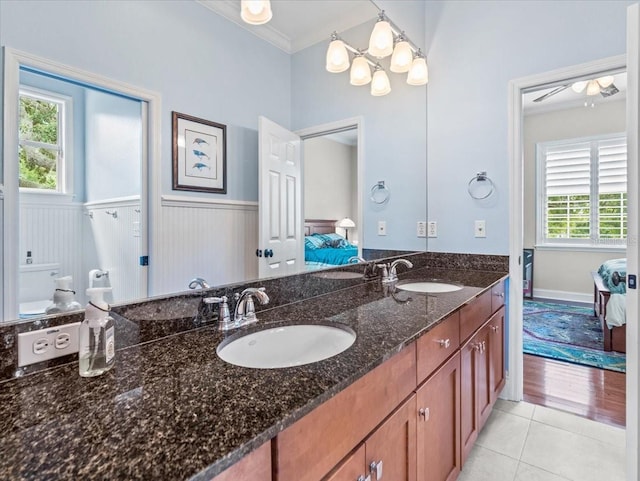 bathroom with double sink, tile floors, crown molding, and vanity with extensive cabinet space