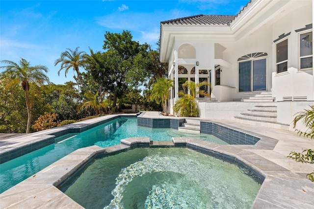 view of swimming pool with an in ground hot tub