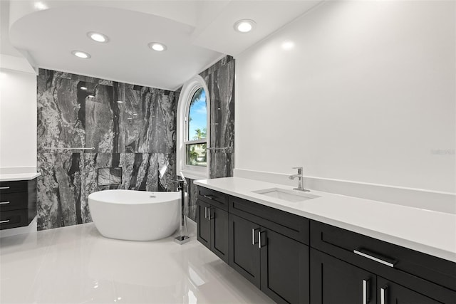 bathroom featuring vanity, tile walls, a bathtub, and tile patterned floors