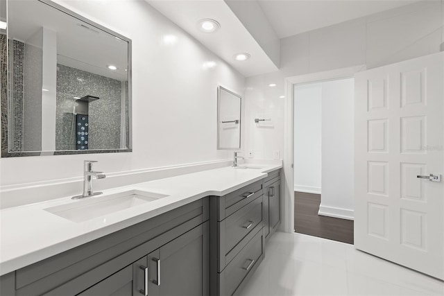 bathroom featuring vanity, tiled shower, and tile patterned flooring