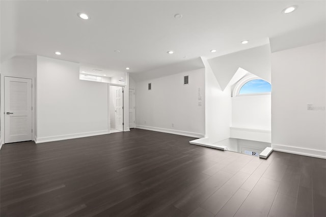 unfurnished living room with vaulted ceiling and dark hardwood / wood-style floors