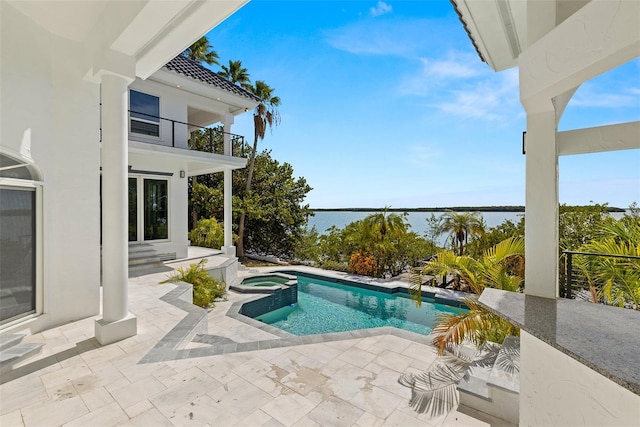 view of swimming pool with a water view, a patio, and an in ground hot tub