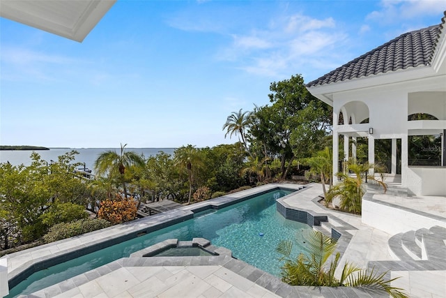 view of swimming pool with a patio area and a water view