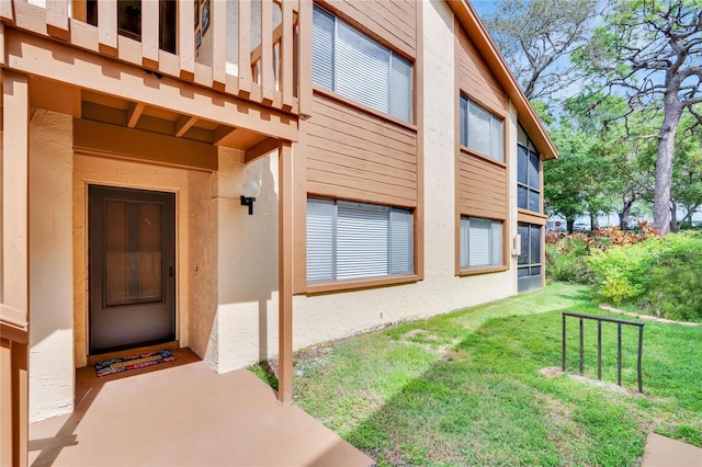 entrance to property with a lawn