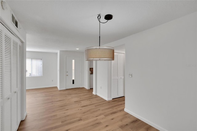 unfurnished dining area featuring light wood-type flooring