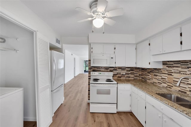 kitchen with tasteful backsplash, washer / clothes dryer, light hardwood / wood-style flooring, white appliances, and white cabinets