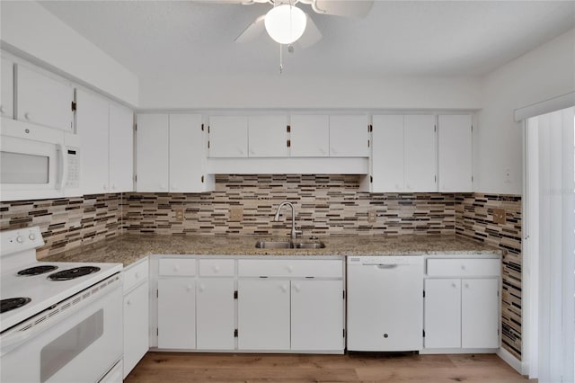 kitchen with white appliances, backsplash, sink, and light hardwood / wood-style flooring