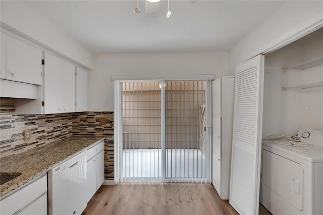 kitchen featuring light hardwood / wood-style floors, washer / clothes dryer, white cabinetry, and light stone counters