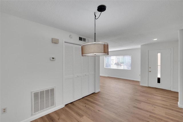 unfurnished dining area featuring light wood-type flooring