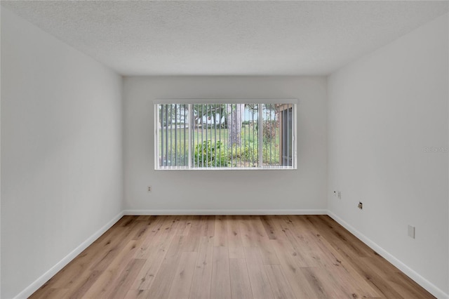 empty room featuring light hardwood / wood-style floors and a textured ceiling