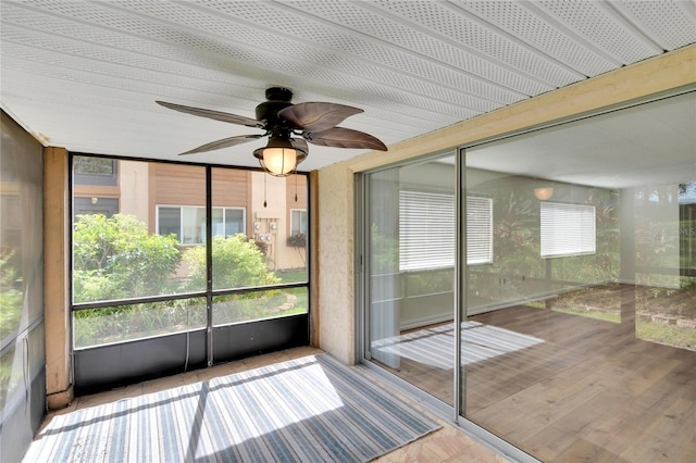 unfurnished sunroom featuring ceiling fan