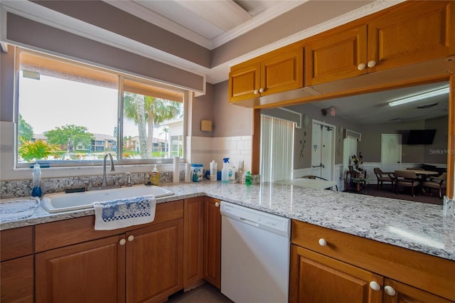 kitchen featuring sink, light stone counters, crown molding, dishwasher, and tasteful backsplash