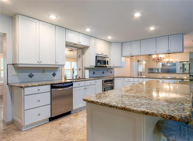 kitchen with tasteful backsplash, light stone counters, light tile floors, a breakfast bar, and appliances with stainless steel finishes