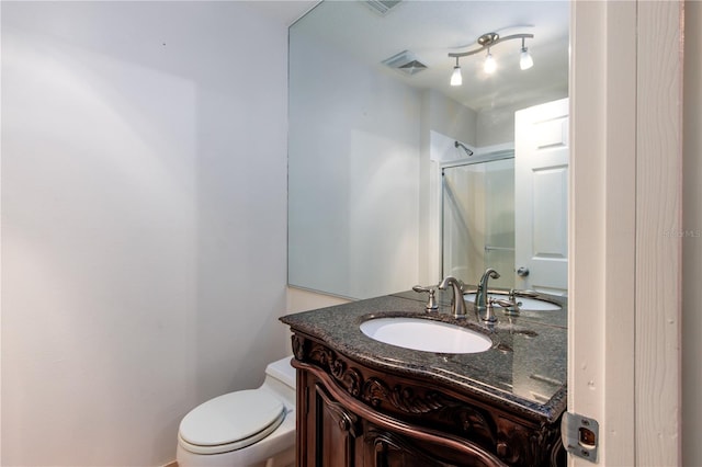 bathroom with oversized vanity, toilet, and rail lighting