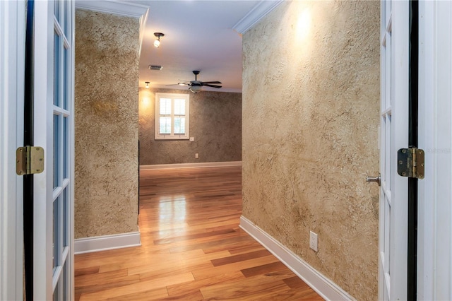 hall with ornamental molding and light hardwood / wood-style flooring