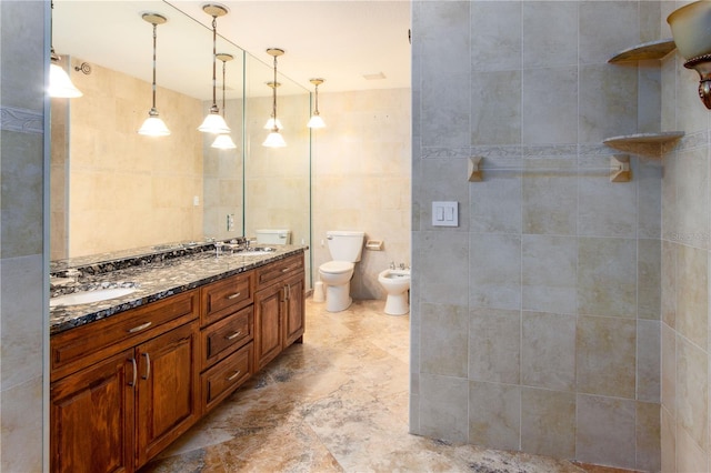 bathroom with double vanity, tile floors, a bidet, tile walls, and toilet