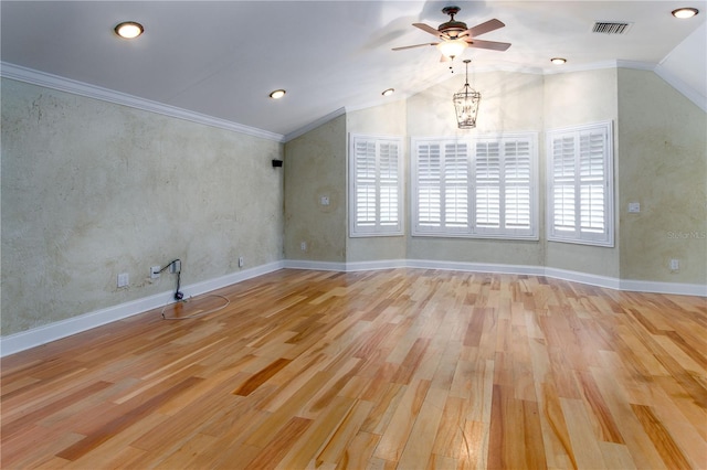 empty room with ceiling fan with notable chandelier, ornamental molding, light hardwood / wood-style flooring, and lofted ceiling