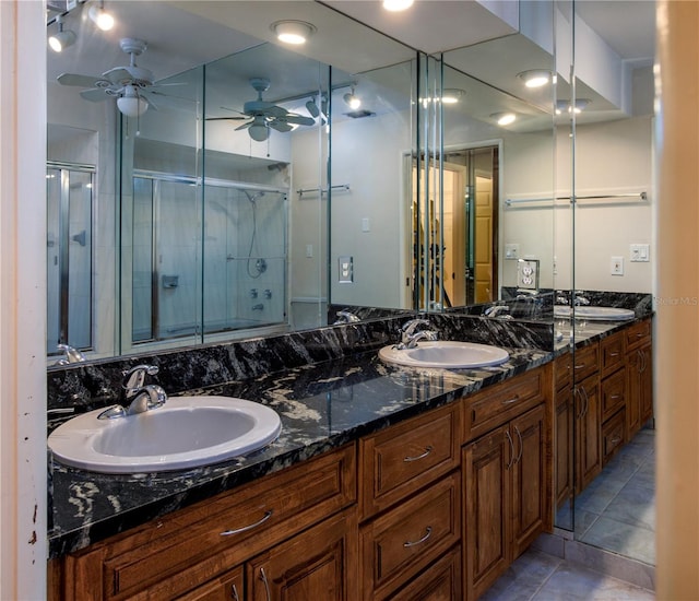 bathroom featuring a shower with shower door, double vanity, tile flooring, and ceiling fan