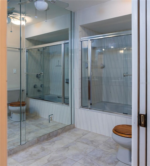 bathroom with tile floors, ceiling fan, combined bath / shower with glass door, and toilet