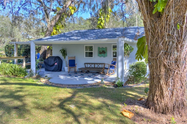 rear view of house with a carport and a yard