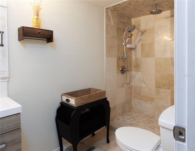 bathroom with tile flooring, tiled shower, toilet, and vanity