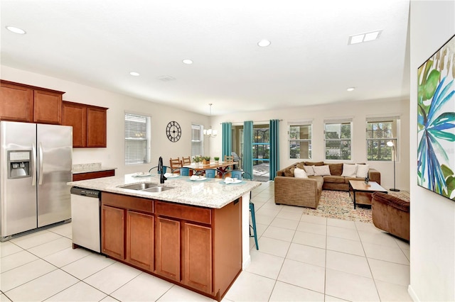 kitchen with stainless steel fridge with ice dispenser, a kitchen island with sink, dishwashing machine, decorative light fixtures, and sink