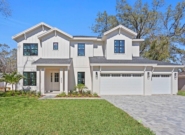 modern inspired farmhouse with a garage, a shingled roof, decorative driveway, board and batten siding, and a front yard