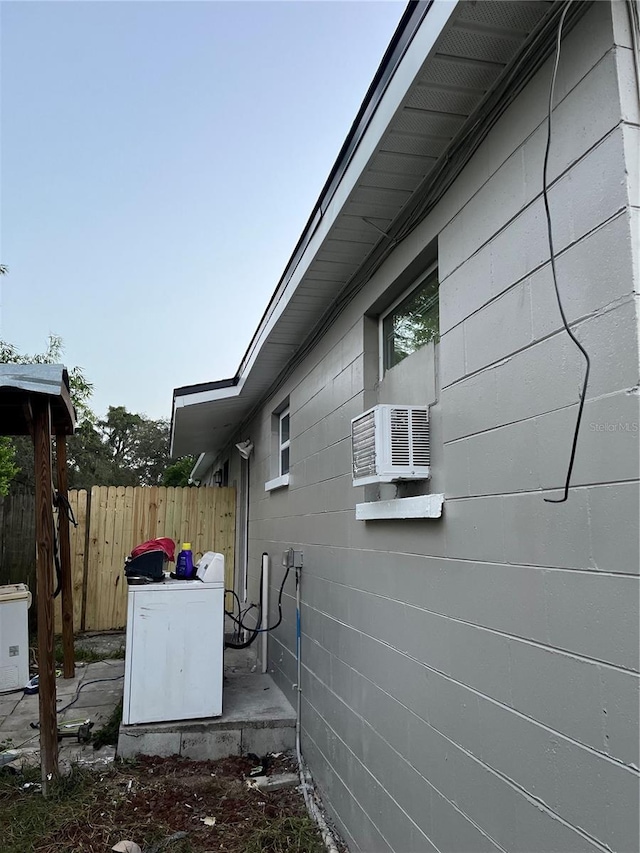 view of property exterior featuring washer / clothes dryer and cooling unit