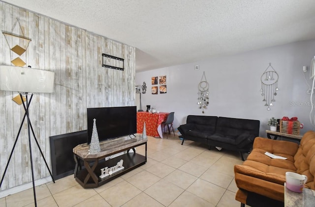 tiled living room with a textured ceiling and wood walls