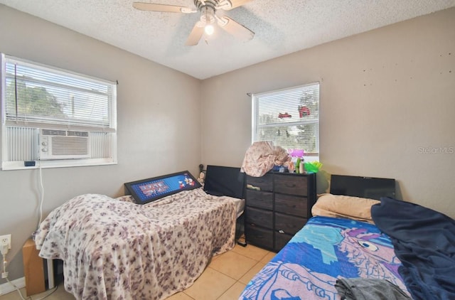 bedroom with a textured ceiling, ceiling fan, cooling unit, and light tile patterned flooring